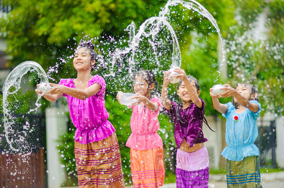 Kids celebrating Songkran with laughter and water play — a joyful scene shared across mainland Southeast Asia each April.